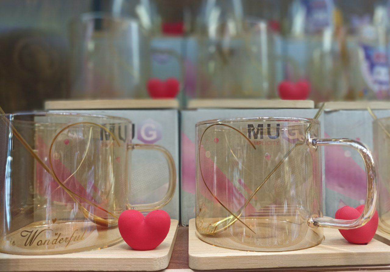 فنجان شیشه ای زیر چوبی با قاشق و قلب